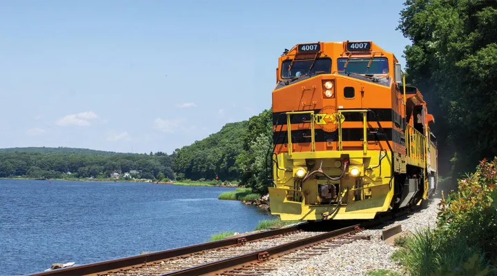 Front view of a train on tracks next to a lake