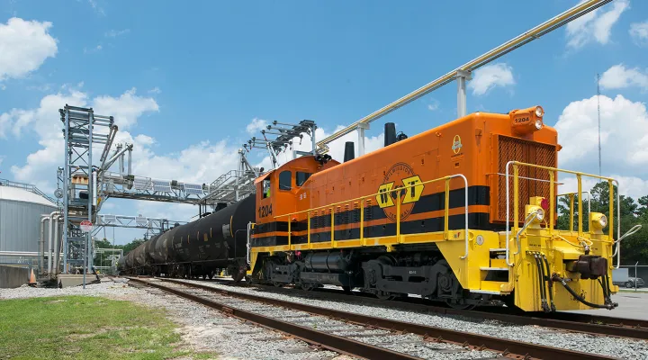 Train caboose connected to tank cars at an industrial complex